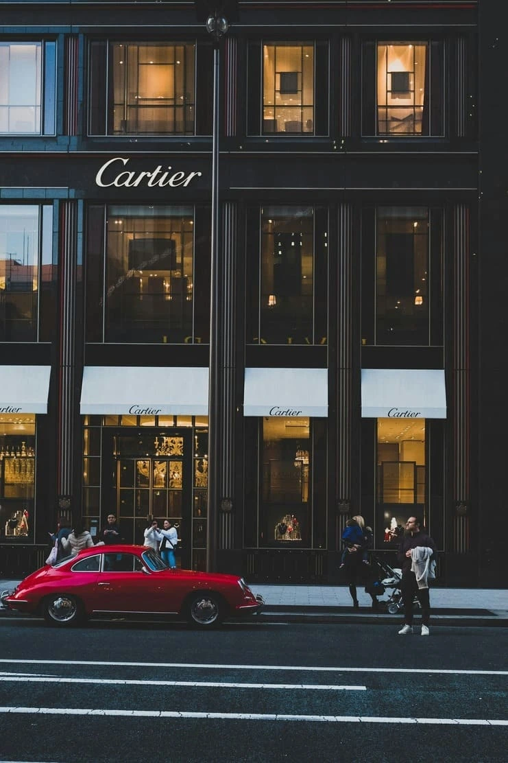 cartier and red car with people